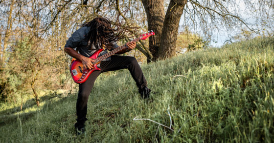 headbanging playing bass on a hill